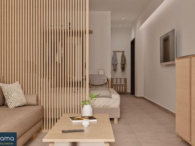 Habitación de hotel moderna con sofá, mesa de café y televisor montado en la pared.