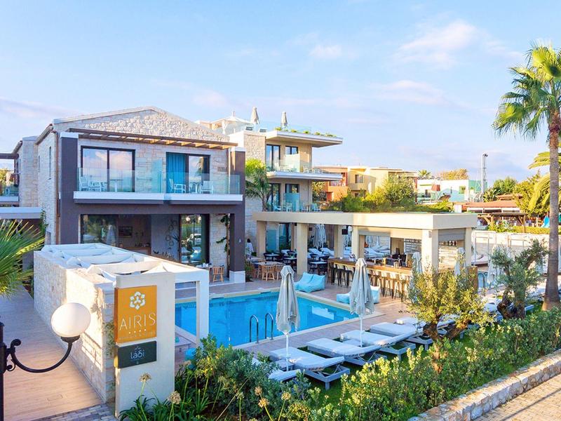 Modern vacation home with pool, sun terrace, and palm trees in sunny surroundings.