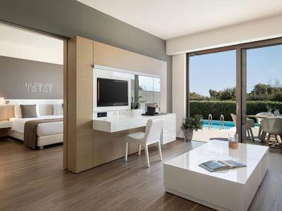 Habitación de hotel moderna con balcón, vista a la piscina, escritorio y diseño minimalista.