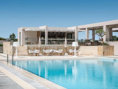 Moderner Außenpool mit Liegestühlen und Lounge-Bereich unter blauem Himmel