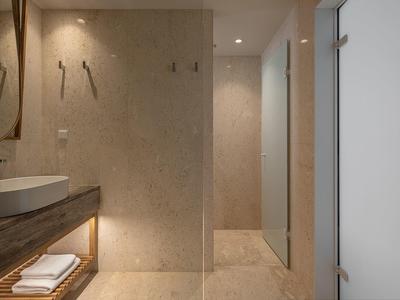 Baño moderno con lavabo, pileta y estante iluminado para toallas debajo de la encimera de madera.