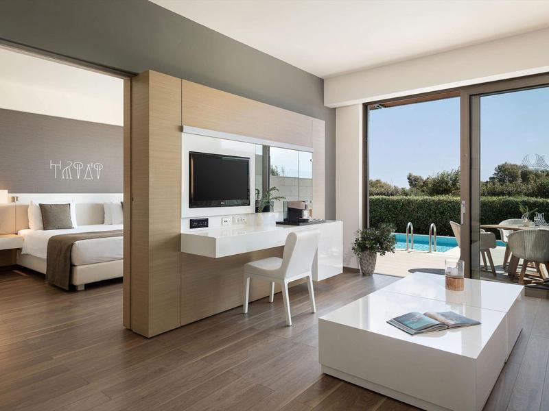 Habitación de hotel moderna con balcón, vista a la piscina, escritorio y diseño minimalista.