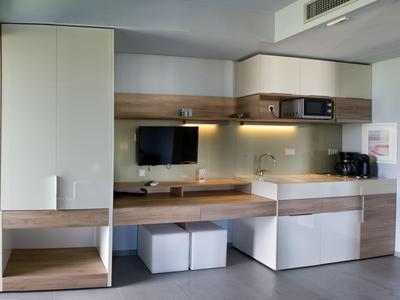 Nowoczesny pokój hotelowy z telewizorem, mikrofalówką, ekspresem do kawy i miejscem do przechowywania.