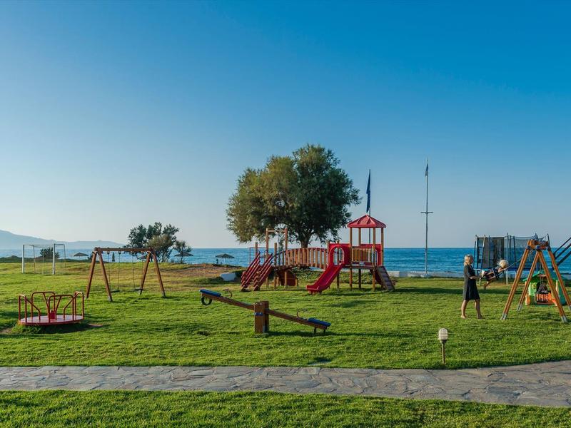 Plac zabaw z huśtawkami i konstrukcjami do wspinaczki nad morzem pod jasnym niebem.