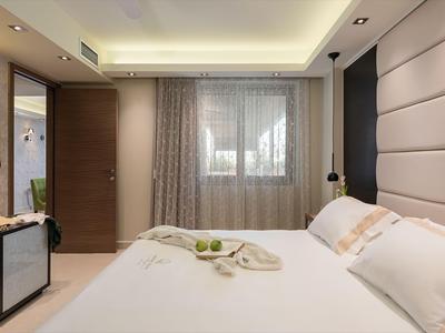 Chambre d'hôtel moderne avec grand lit et fenêtre avec rideaux.