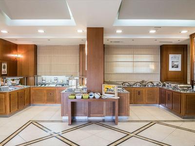 Salle de petit-déjeuner spacieuse avec meubles en bois et buffet dans un hôtel.