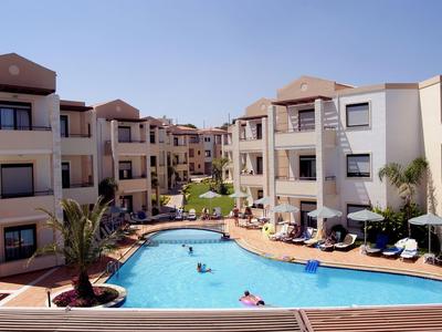 Moderner Hotelkomplex mit Außenpool und Liegestühlen bei klarem Himmel.