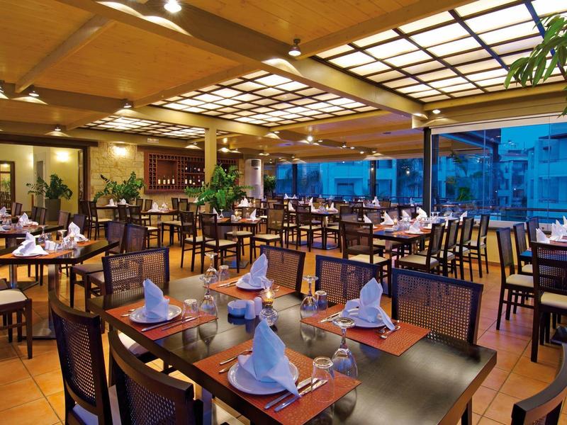 Elegant restaurant with set tables and wooden furniture in a warmly lit room.