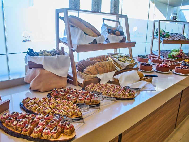Buffet with various open-faced sandwiches and snacks in a bright room.