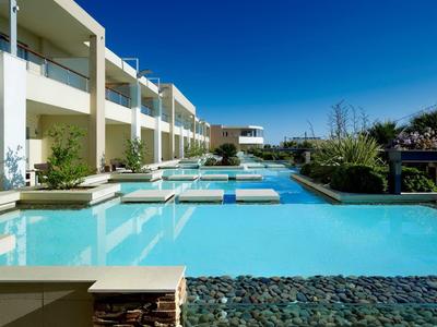 Modernes Hotel mit Außenpool und klarem blauem Himmel im Hintergrund.