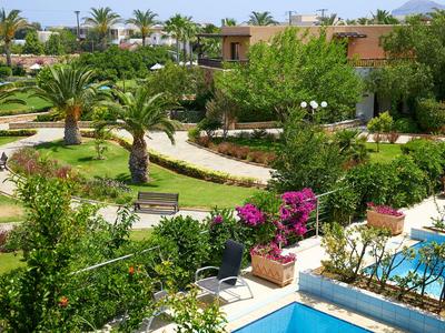 Grüner Garten mit Palmen, Blumen und Weg in einem Hotel mit Pool