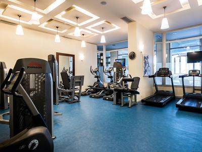 Moderner Fitnessraum mit Trainingsgeräten und Laufbändern in einem Hotel.