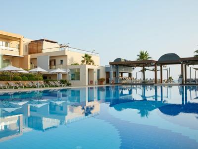 Piscine d'hôtel moderne avec transats, pavillons et eau bleu clair sous un ciel dégagé.