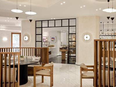 Restaurant moderne avec mobilier en bois, murs clairs et disposition spatiale nette.