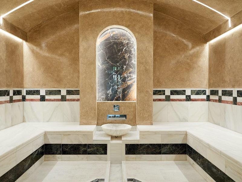 Moderní spa místnost s dávkovačem vody uprostřed a elegantním osvětlením