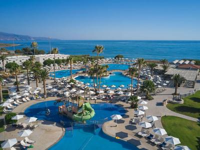 Vista di un resort con piscine, sdraio e palme vicino al mare