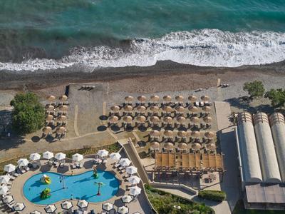 Vista aerea di un'area resort con piscina, ombrelloni e spiaggia sul mare