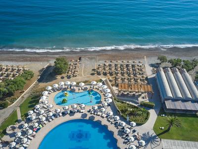 Vista di un hotel con due piscine, lettini e accesso diretto alla spiaggia.