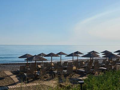 Strand mit Reihen von Sonnenschirmen und Stühlen unter klarem Himmel