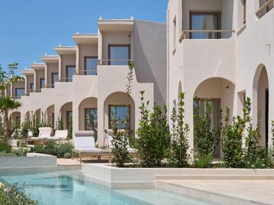 Moderner Hotelkomplex mit Pool, Terrassen und mediterraner Architektur bei klarem Himmel.