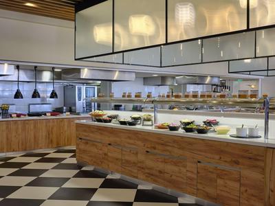 Moderne Buffetstation in einem Restaurant mit Holzakzenten und Beleuchtung.