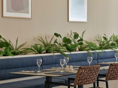 Salle à manger moderne avec banquette bleue et verres à vin sur la table