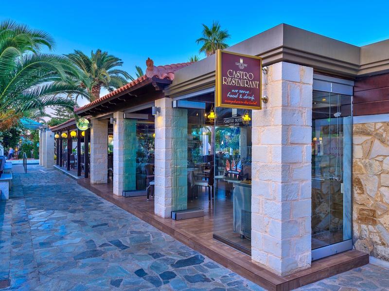 Modern hotelrestaurant met glazen ramen en tropische planten langs het pad.