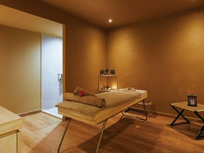 Una habitación tranquila de spa con una mesa de masajes, iluminación suave y ambiente relajante.