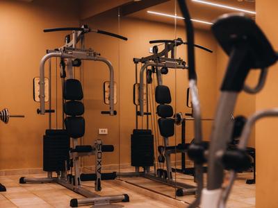 Pequeño gimnasio con máquinas de ejercicio y luz cálida en una habitación de hotel.