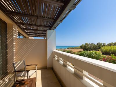 Balkon mit Stühlen und Meerblick unter klarem Himmel.