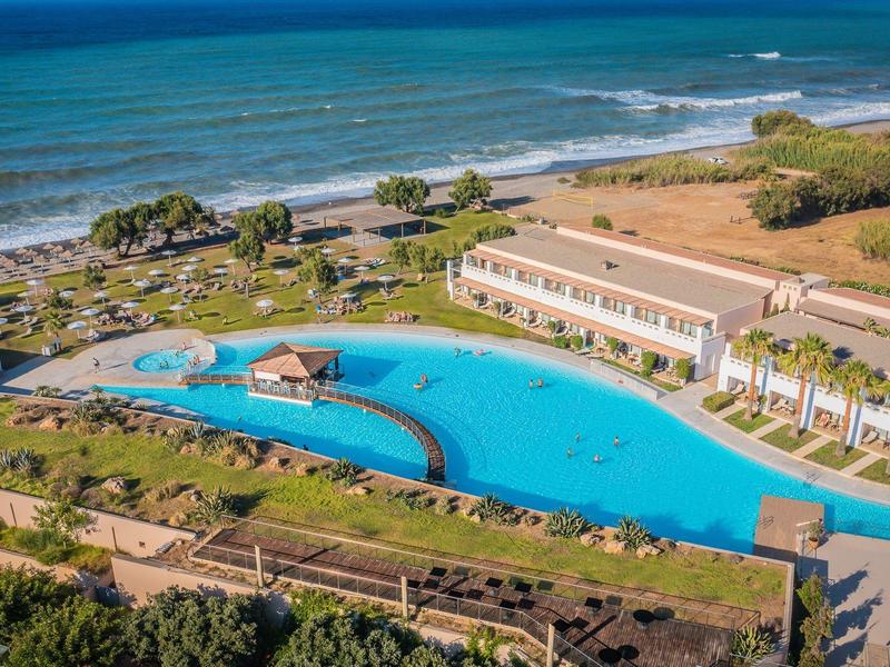 Gran piscina con isla redonda junto a un edificio junto al mar en un complejo turístico.