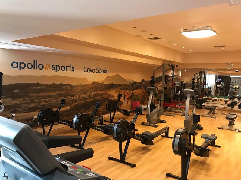 Gimnasio bien equipado con remoergómetros y maquinaria moderna en un hotel.