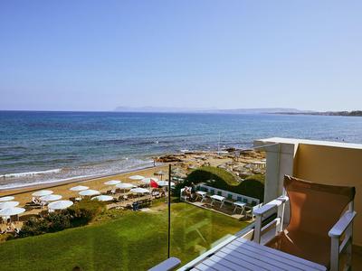 Blick von einem Hotelbalkon auf den Strand mit Sonnenschirmen und das blaue Meer.
