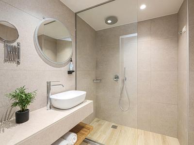 Modernes Hotelbadezimmer mit bodengleicher Dusche und elegantem Waschbecken.