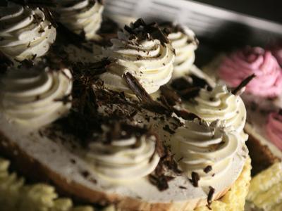 Gros plan de desserts crémeux garnis de copeaux de chocolat sous une lumière chaude.