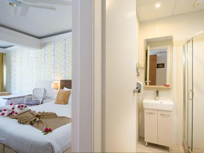 Vue d'une chambre d'hôtel avec deux lits et salle de bains adjacente avec lavabo et douche.