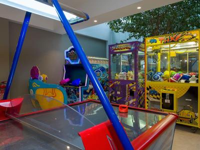 Innenraum mit Spielgeräten wie Airhockey und Greifautomaten in einem Freizeitraum.