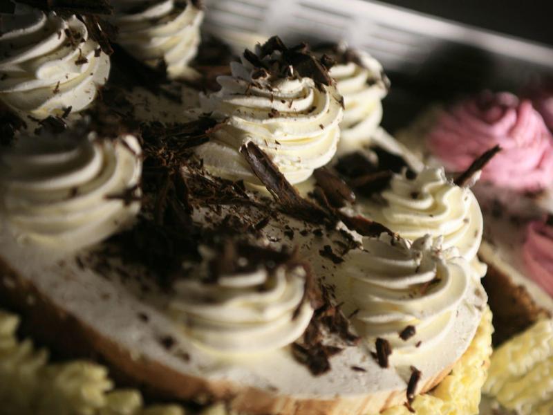 Gros plan de desserts crémeux garnis de copeaux de chocolat sous une lumière chaude.