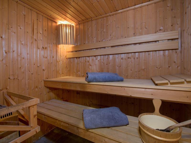 Sauna confortable avec boiseries, bancs, serviettes et accessoires de sauna.