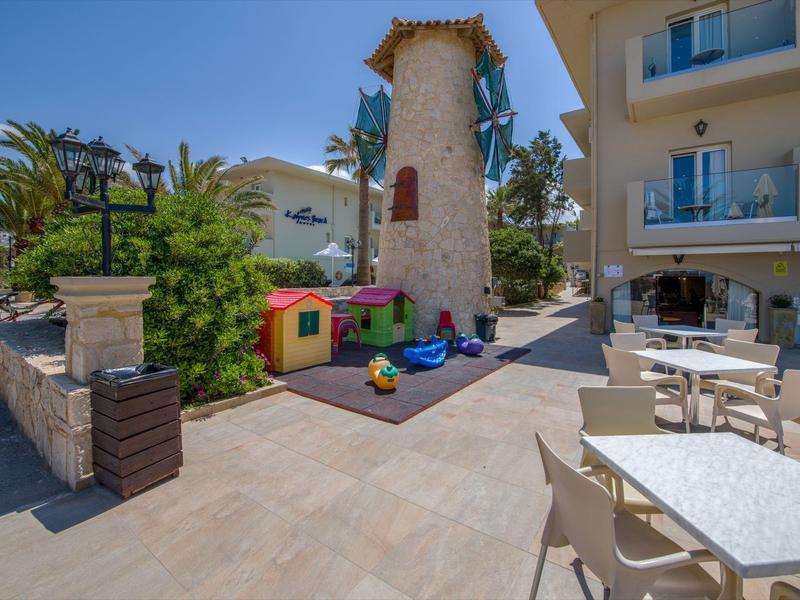 Patio extérieur avec tables, aire de jeux pour enfants et tour en pierre décorative