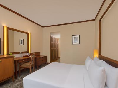 Gemütliches Hotelzimmer mit Doppelbett, Holzmöbeln und warmem Beleuchtungskonzept.