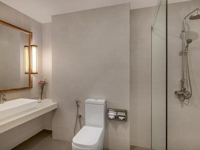 Modernes Badezimmer mit großem Spiegel, Waschtisch, WC und begehbarer Dusche mit Glaswand.