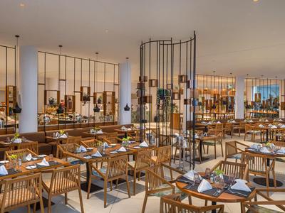 Moderner, heller Speisesaal mit Holztischen und Stühlen in elegantem Hotelrestaurant.