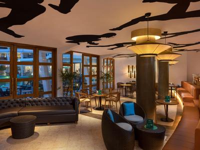 Elegante Hotel-Lounge mit modernen Sitzgelegenheiten und warmem Lichtkonzept.