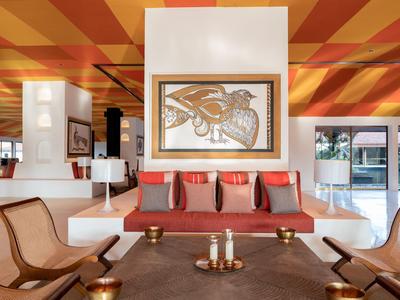 Modern eingerichteter Hotel-Lounge-Bereich mit gemütlichen Sesseln, Sofa und dekorativen Elementen.