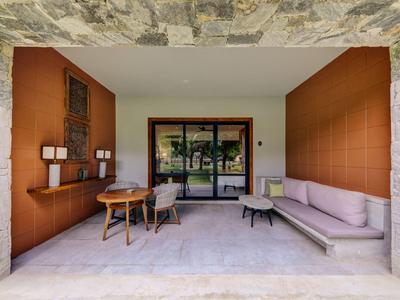 Moderner Hotelbalkon mit komfortabler Sitzgruppe und Blick auf einen Garten.