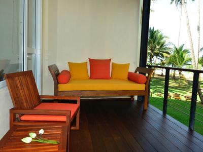 Balkon z kolorowymi miejscami do siedzenia z widokiem na tropikalny ogród i palmy.