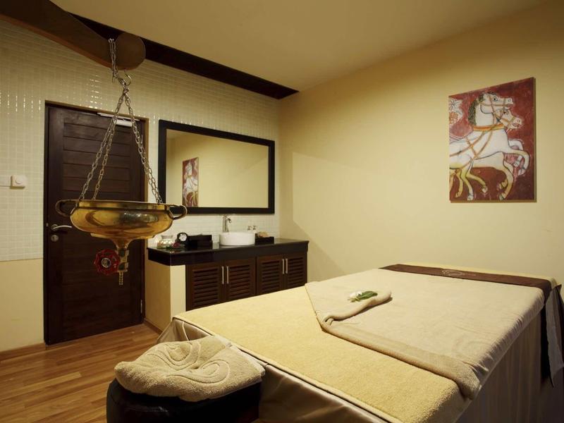 Salle de massage accueillante avec table de massage, serviettes et décoration apaisante.