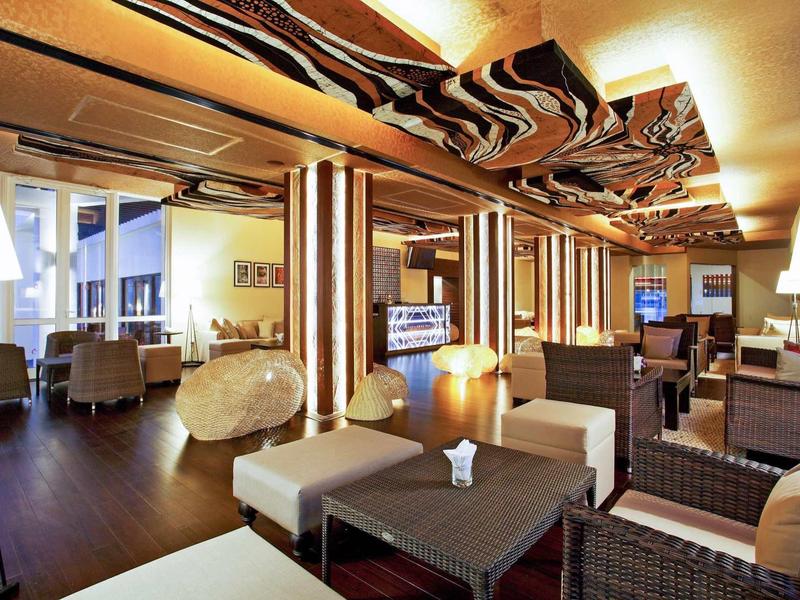 Hall d'hôtel moderne avec espaces de détente confortables et décorations originales au plafond.