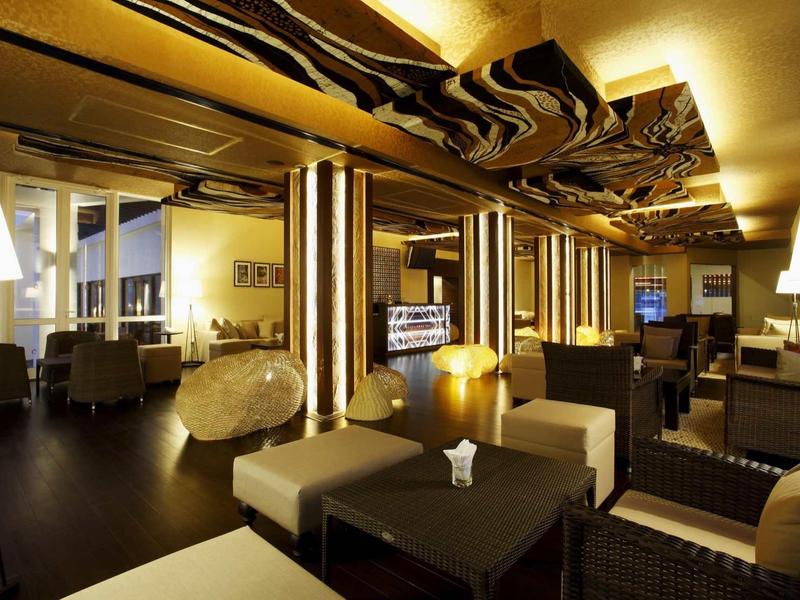 Espace lounge d'hôtel moderne avec sièges confortables et éclairage indirect.